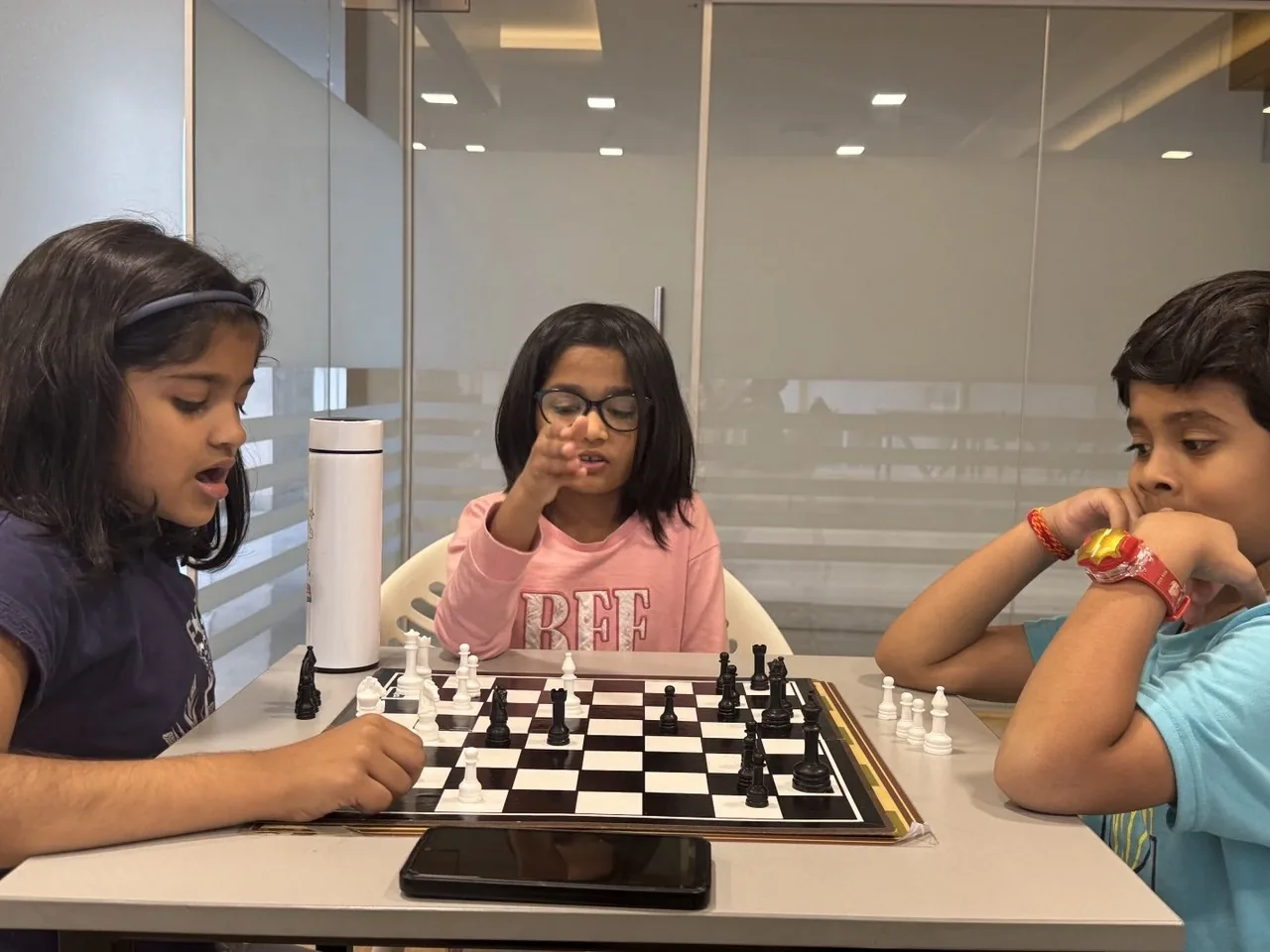 Girls concentrating on a chess match during class at GKS Academy