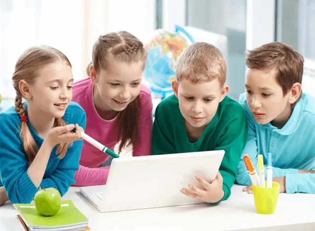 Children learning together around a laptop